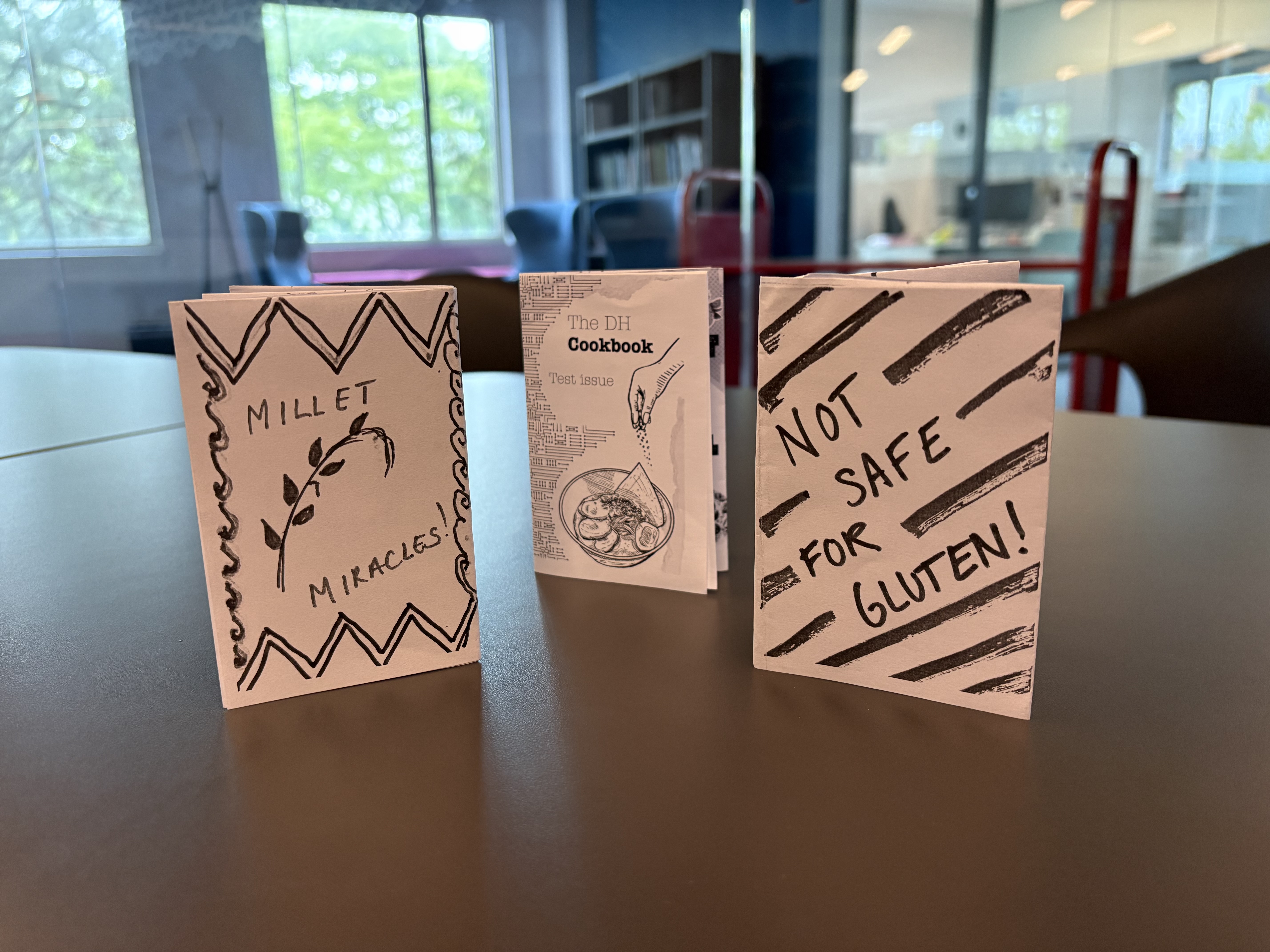 a trio of one page zines standing up on a table